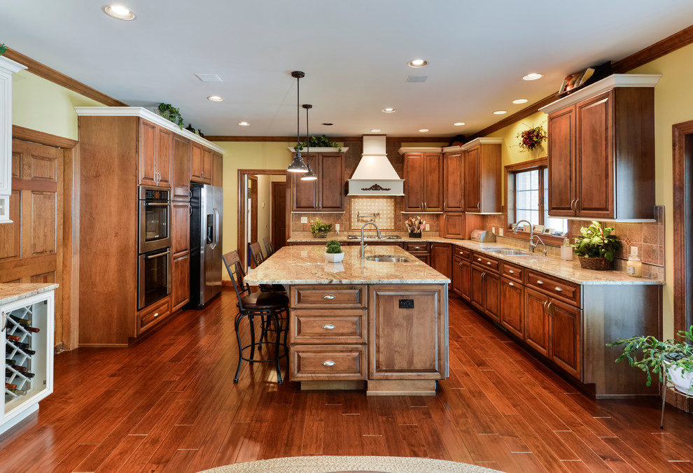 Eat-in kitchen - large transitional u-shaped medium tone wood floor eat-in kitchen idea with beaded inset cabinets, medium tone wood cabinets, granite countertops, beige backsplash, mosaic tile backsplash, stainless steel appliances and an island