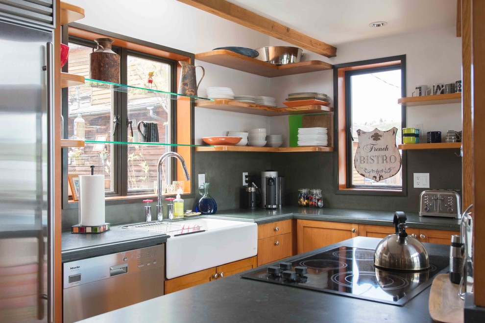 Photo of a mid-sized country l-shaped eat-in kitchen in Seattle with a farmhouse sink, shaker cabinets, medium wood cabinets, soapstone benchtops, grey splashback, stainless steel appliances and with island.