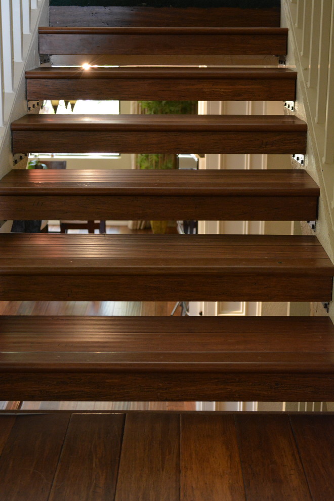 Wooden floating staircase photo in Orange County with wooden risers