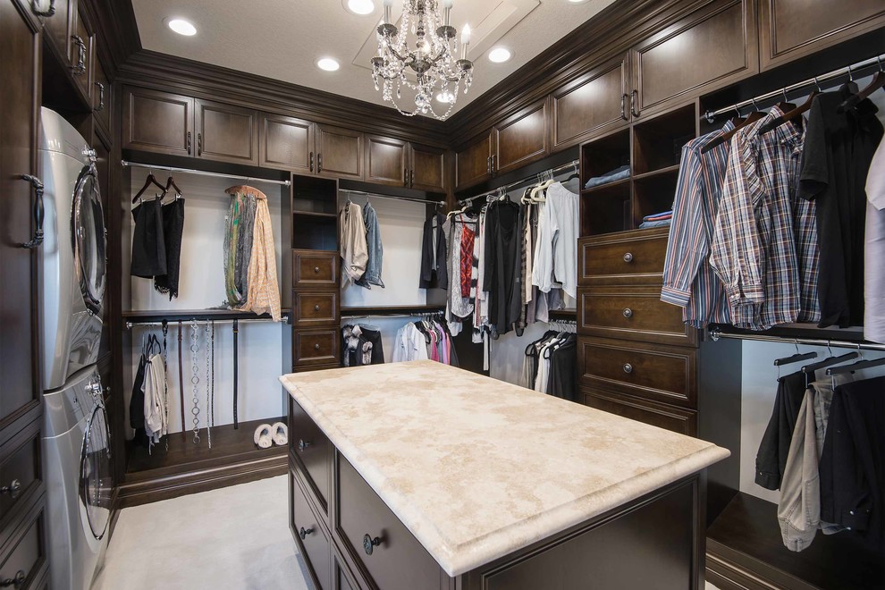 Expansive traditional gender-neutral walk-in wardrobe in Other with dark wood cabinets and carpet.