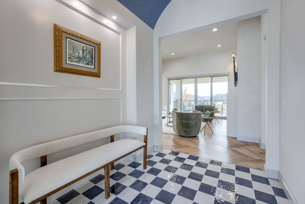 Foyer - wainscoting foyer idea in Omaha with white walls and a black front door