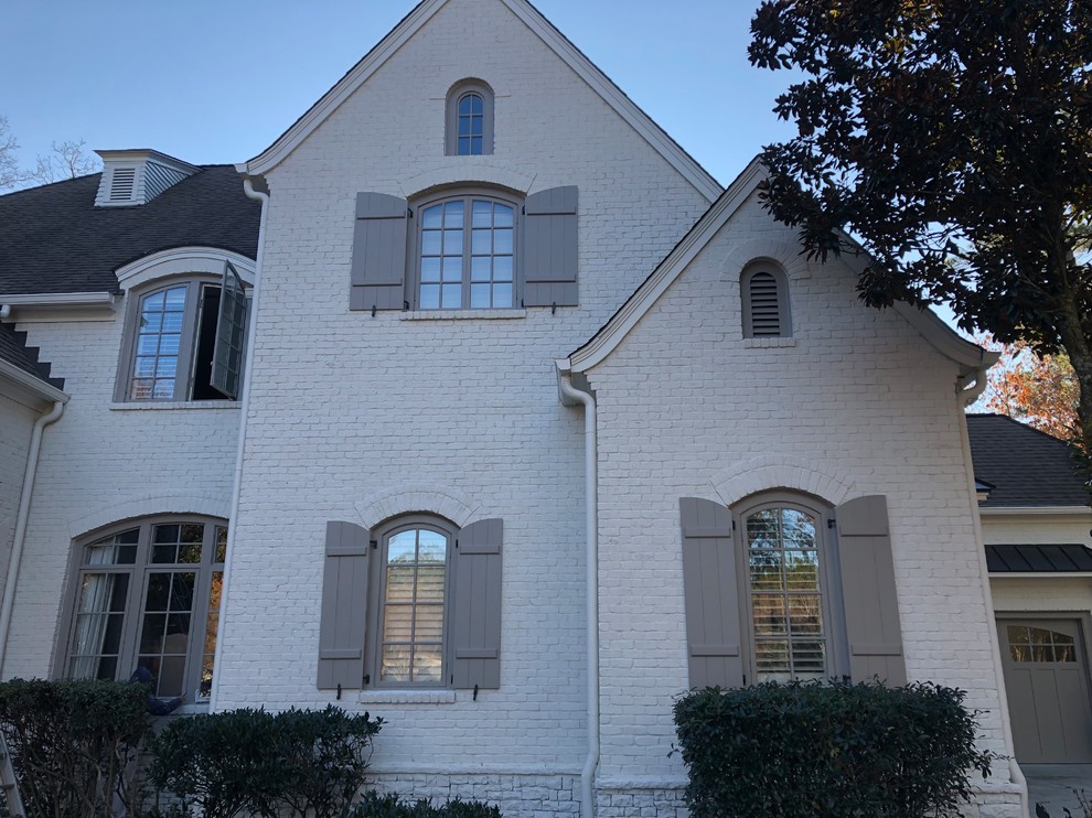 Photo of a large transitional three-storey brick white house exterior in Atlanta with a gable roof and a shingle roof.