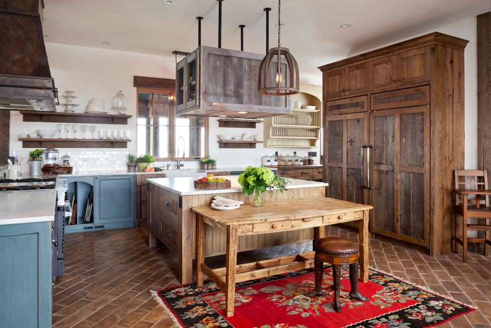 Photo of a country u-shaped kitchen in Denver with a farmhouse sink, white splashback, ceramic splashback, panelled appliances, terra-cotta floors, with island, open cabinets and dark wood cabinets.