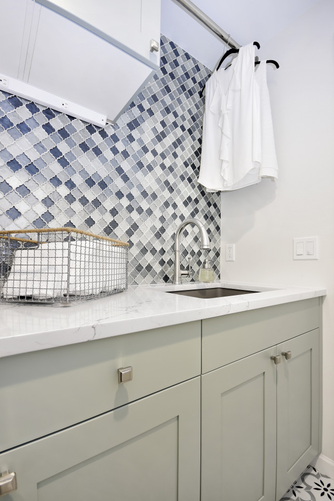 Inspiration for a mid-sized contemporary single-wall ceramic tile and white floor laundry room remodel in Seattle with an undermount sink, shaker cabinets, green cabinets, quartz countertops, multicolored backsplash, glass tile backsplash, white walls, a side-by-side washer/dryer and white countertops