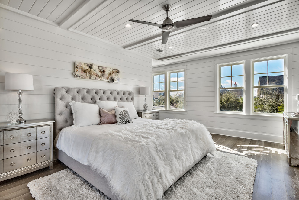 Inspiration for a mid-sized beach style master bedroom in Miami with white walls, dark hardwood floors, brown floor and no fireplace.
