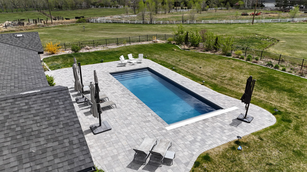 Large backyard brick and rectangular pool photo