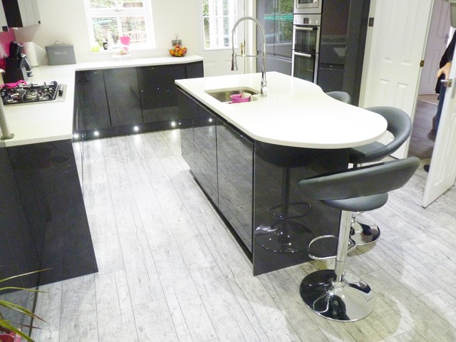 Gloss lacquered 'graphite' handleless kitchen with white quartz worktops contemporaneo-cocina