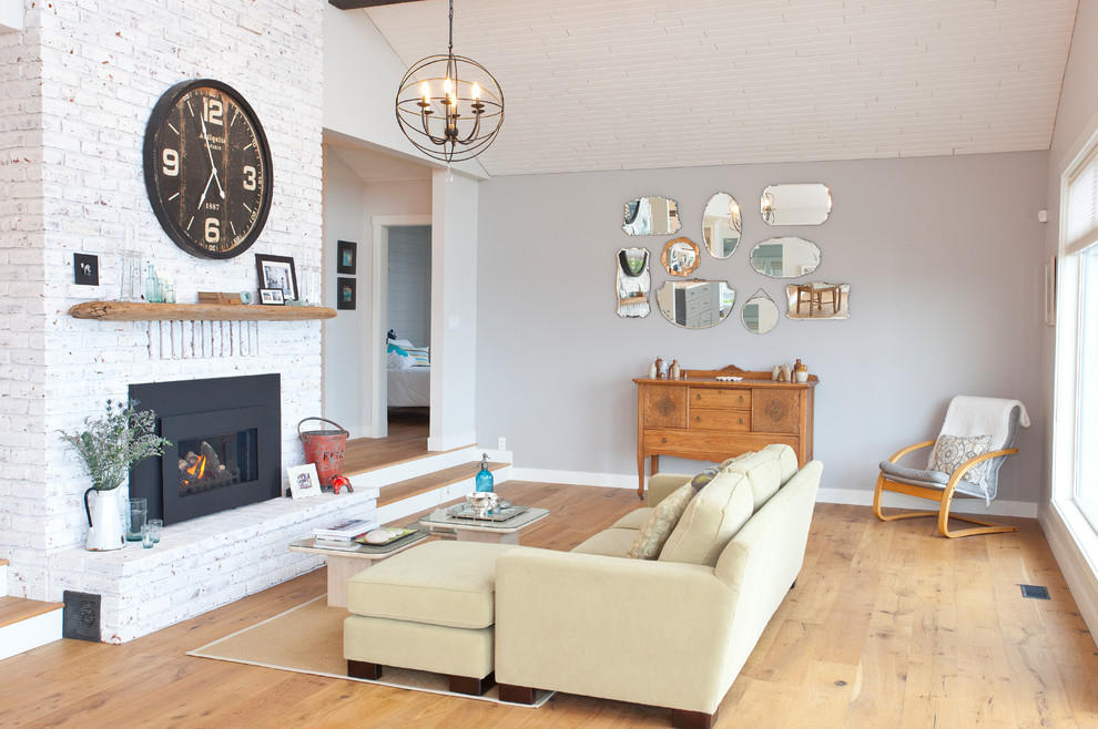 Photo of a large transitional formal open concept living room in Vancouver with grey walls, light hardwood floors, a standard fireplace, a metal fireplace surround, no tv and beige floor.