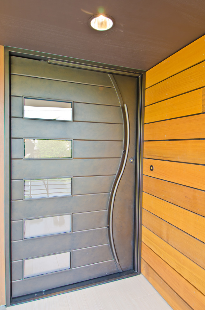Photo of a large contemporary front door in Seattle with a pivot front door and a metal front door.