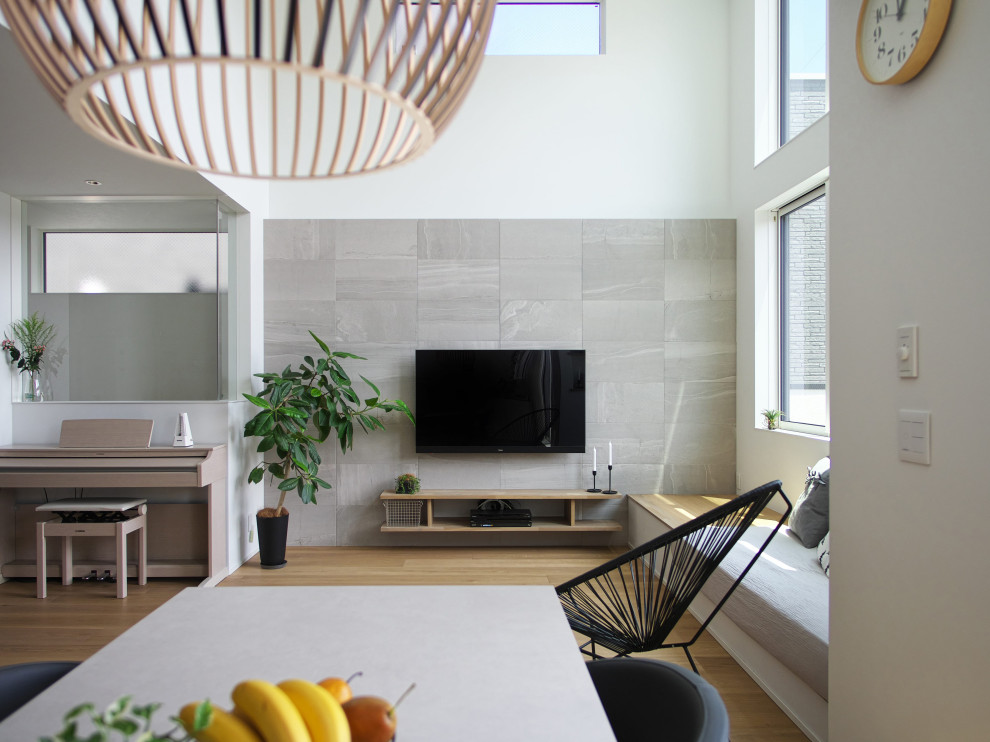 Inspiration for a scandinavian open concept living room in Osaka with grey walls, medium hardwood floors, no fireplace, a wall-mounted tv, wallpaper and wallpaper.