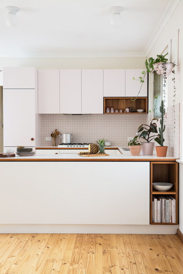 Inspiration for a small midcentury u-shaped open plan kitchen in Adelaide with flat-panel cabinets, laminate benchtops, white splashback, ceramic splashback, white appliances and light hardwood floors.