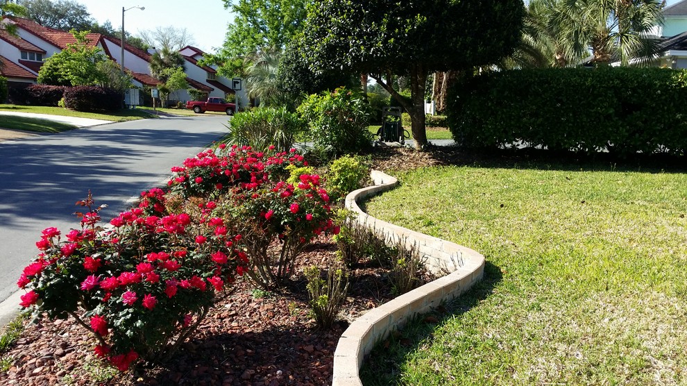 Inspiration for a small traditional front yard full sun driveway in Miami with a retaining wall and concrete pavers.