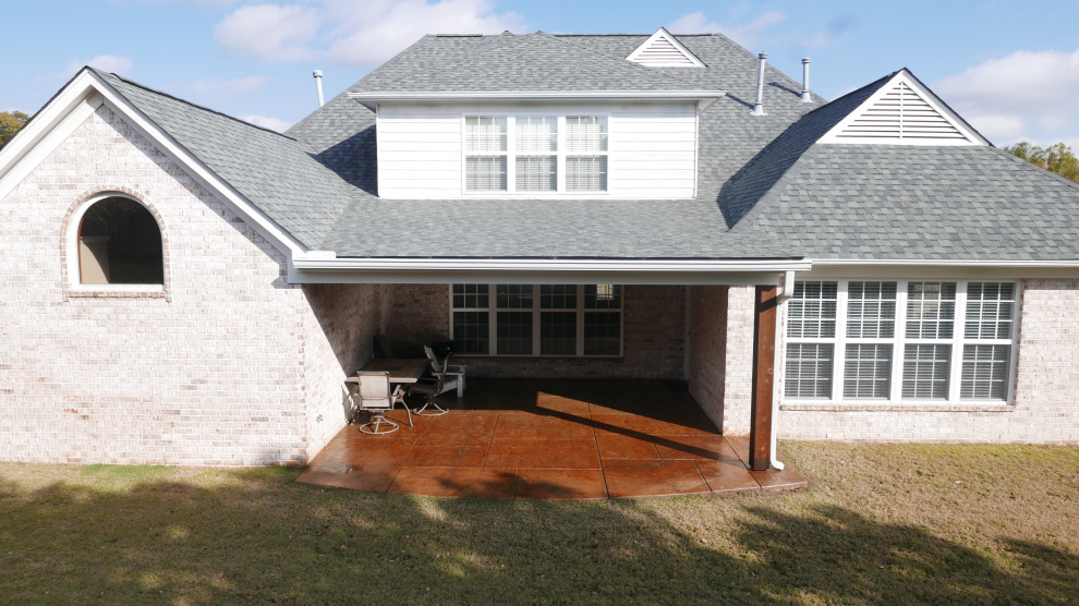 Inspiration for a mid-sized timeless stamped concrete porch remodel in Other with a roof extension