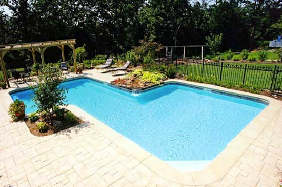 Backyard stone and custom-shaped pool photo
