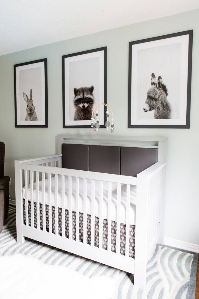 Design ideas for a mid-sized modern nursery for boys in Toronto with green walls and light hardwood floors.