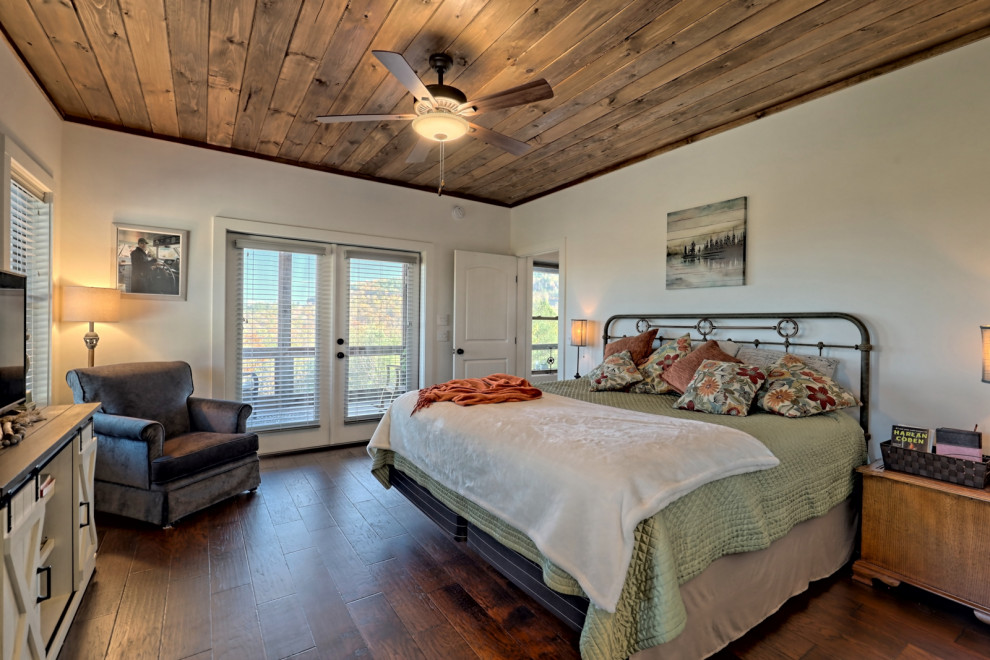 Idée de décoration pour une grande chambre parentale craftsman avec un mur blanc, parquet foncé, aucune cheminée, un sol marron et un plafond en bois.