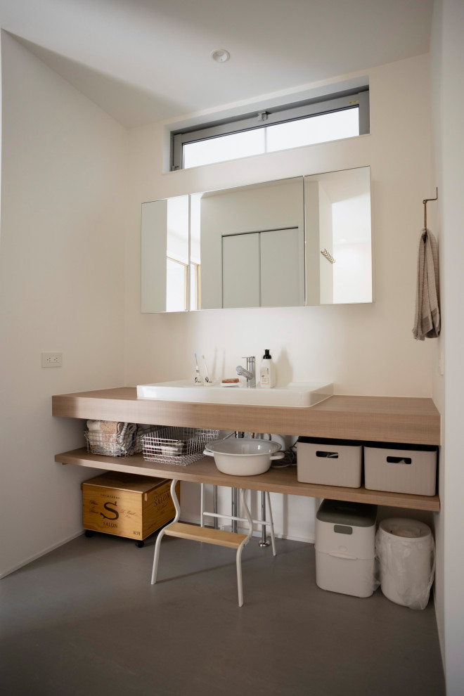 Réalisation d'un petit WC et toilettes chalet en bois clair avec un placard sans porte, un plan de toilette en bois, un plan de toilette blanc et meuble-lavabo suspendu.