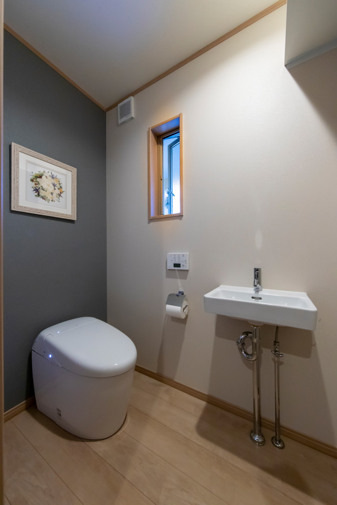 Bild på ett mellanstort beige beige toalett, med vita skåp, en toalettstol med hel cisternkåpa, flerfärgad kakel, mosaik, vita väggar, plywoodgolv och beiget golv