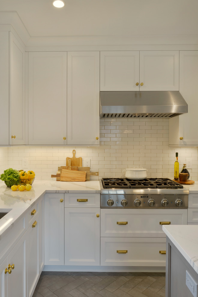 Example of a small transitional u-shaped porcelain tile and gray floor enclosed kitchen design in New York with an undermount sink, recessed-panel cabinets, white cabinets, quartz countertops, white backsplash, ceramic backsplash, stainless steel appliances, an island and white countertops