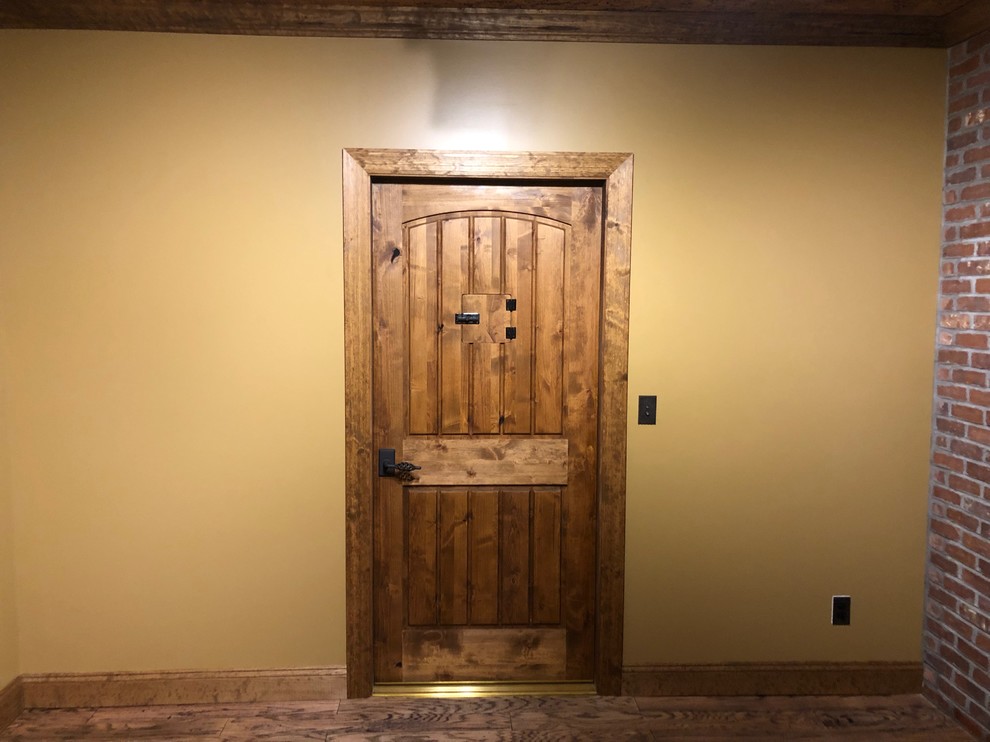 Inspiration for a mid-sized rustic laminate floor and brown floor wine cellar remodel with display racks
