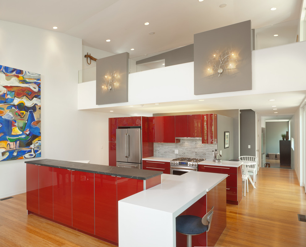 Inspiration for a contemporary kitchen in Houston with flat-panel cabinets, red cabinets, grey splashback, medium hardwood floors and with island.