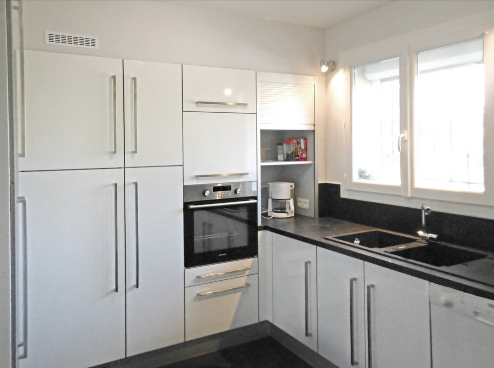 This is an example of a mid-sized contemporary u-shaped separate kitchen in Other with a double-bowl sink, flat-panel cabinets, white cabinets, laminate benchtops, black splashback, stainless steel appliances, ceramic floors, no island, black floor and black benchtop.