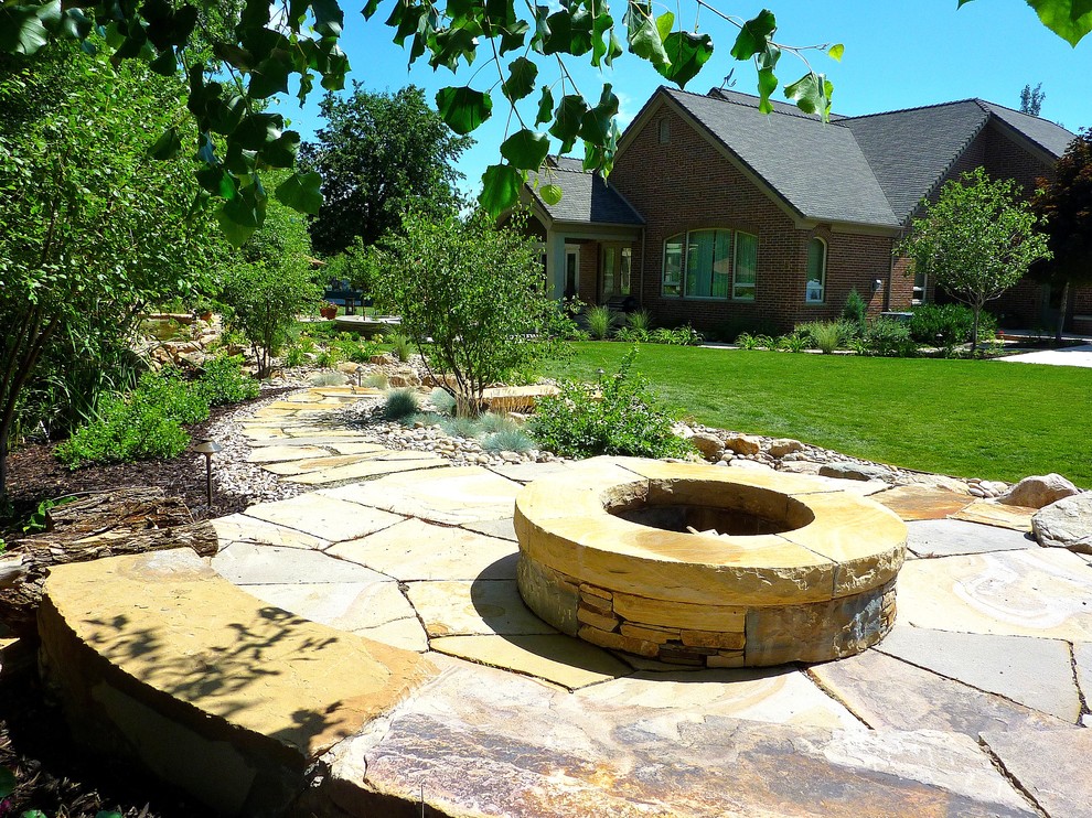 Inspiration for a mid-sized traditional backyard xeriscape in Salt Lake City with a fire feature and natural stone pavers.