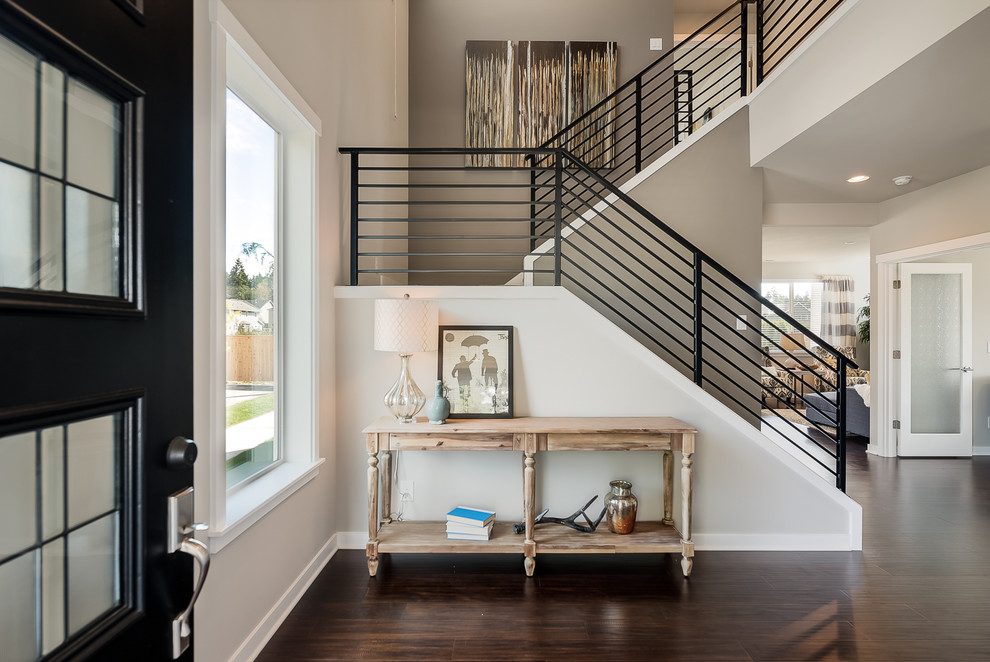 Design ideas for a transitional foyer in Seattle with grey walls, dark hardwood floors, a single front door and a black front door.