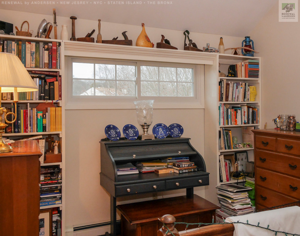 Kleines Lesezimmer ohne Kamin mit weißer Wandfarbe, braunem Holzboden, freistehendem Schreibtisch und gewölbter Decke in Newark