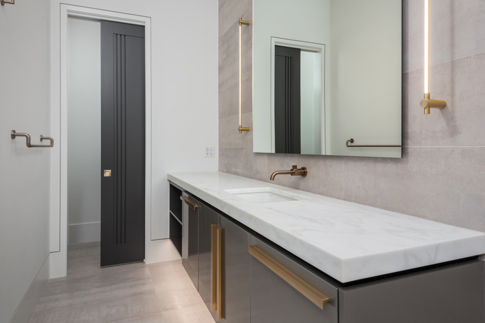 This is an example of an expansive modern master bathroom in Charleston with flat-panel cabinets, grey cabinets, a curbless shower, a two-piece toilet, gray tile, porcelain tile, white walls, porcelain floors, an undermount sink, marble benchtops, grey floor, an open shower, white benchtops, a niche, a double vanity, a floating vanity and vaulted.