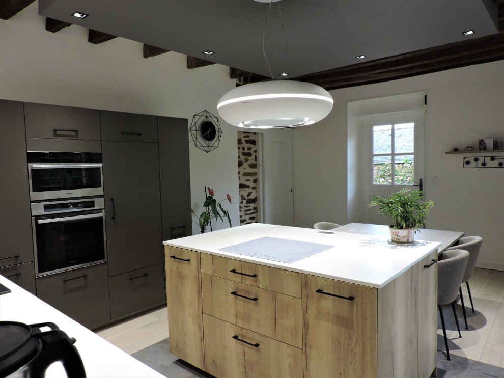 Réalisation de cuisine ouverte in bois clair With un évier 1 bac, un plan de travail en calcaire, une crédence blanche, parquet clair, îlot, un sol marron, un plan de travail blanc and poutres apparentes.