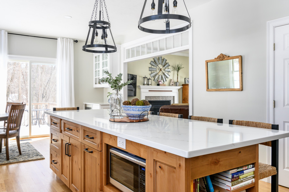 Eat-in kitchen - large country l-shaped light wood floor and brown floor eat-in kitchen idea in Boston with an undermount sink, recessed-panel cabinets, white cabinets, quartz countertops, beige backsplash, ceramic backsplash, stainless steel appliances, an island and white countertops