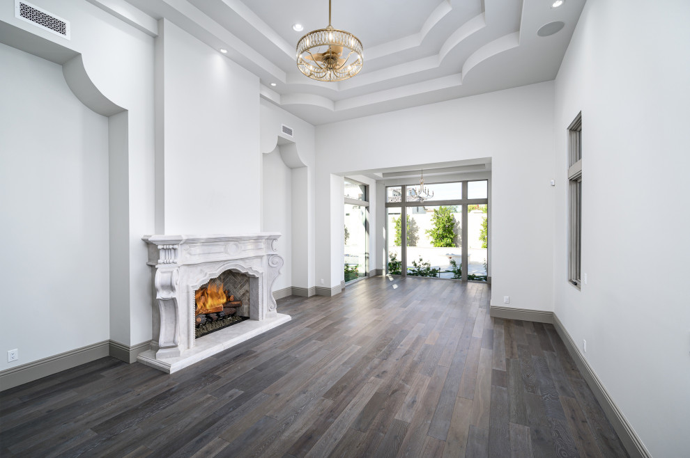 Design ideas for a large modern master bedroom in Phoenix with white walls, dark hardwood floors, a standard fireplace, a concrete fireplace surround, brown floor and recessed.