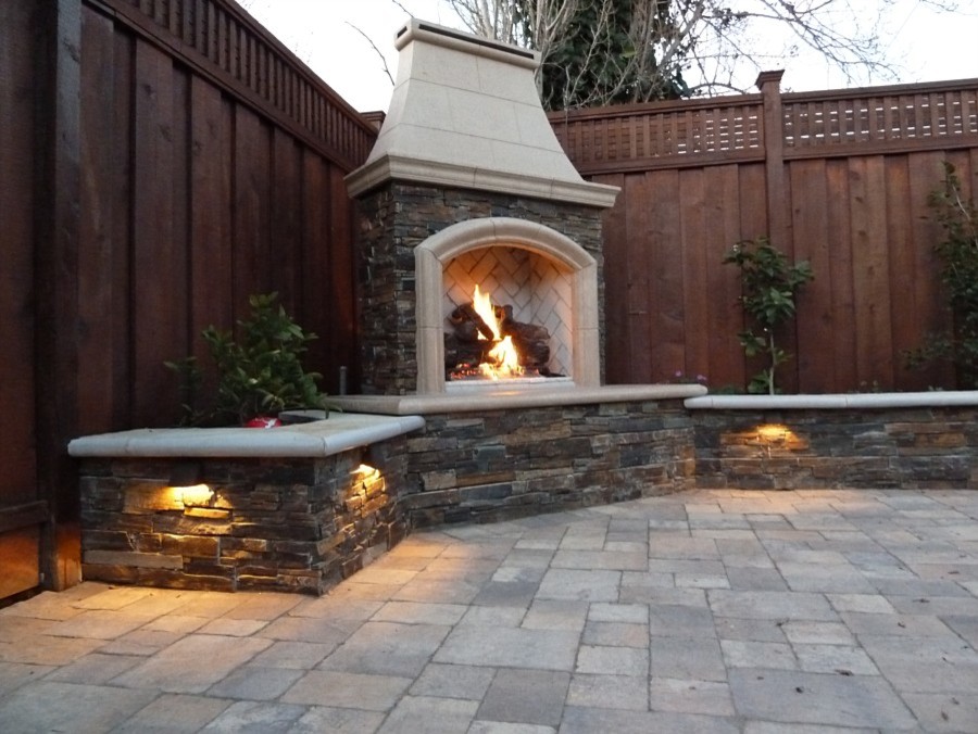This is an example of a mid-sized mediterranean backyard patio in New York with a fire feature, concrete pavers and no cover.