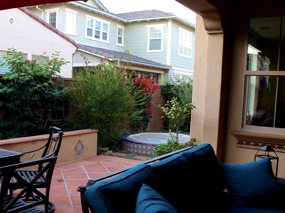 Inspiration for a mid-sized mediterranean backyard patio in Orange County with tile and no cover.