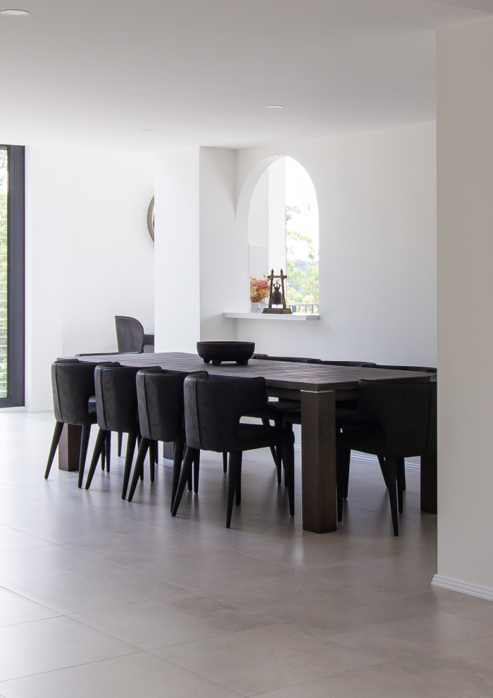 Aménagement d'une grande salle à manger ouverte sur le salon moderne avec un mur blanc, un sol en carrelage de porcelaine et un sol gris.