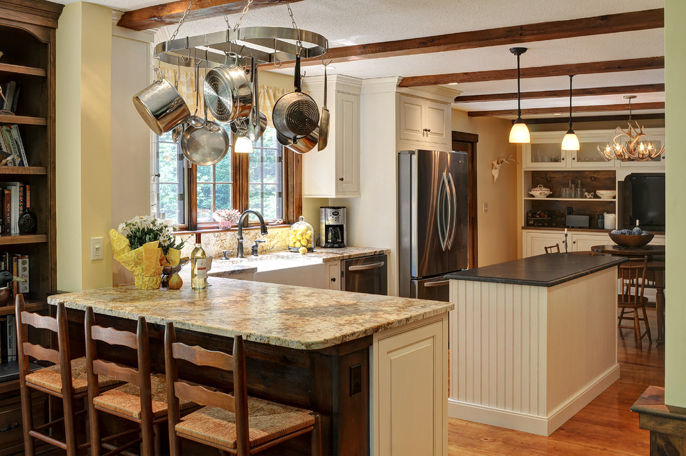 Mid-sized transitional u-shaped medium tone wood floor and brown floor eat-in kitchen photo in Boston with white cabinets, granite countertops, stainless steel appliances, an island, a farmhouse sink, raised-panel cabinets, beige backsplash, stone slab backsplash and beige countertops