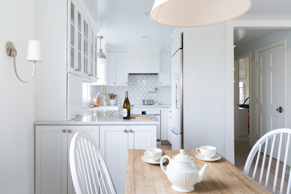 Eat-in kitchen - farmhouse u-shaped light wood floor eat-in kitchen idea in Boston with a farmhouse sink, recessed-panel cabinets, white cabinets, multicolored backsplash, paneled appliances and a peninsula
