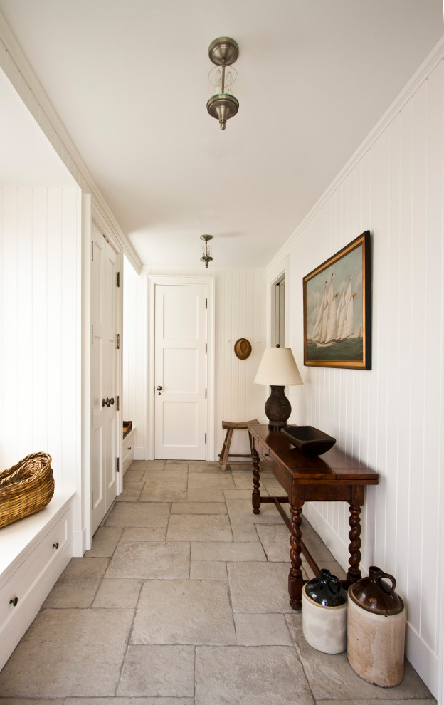 Modelo de vestíbulo posterior tradicional pequeño con paredes blancas, suelo de piedra caliza, puerta simple, puerta blanca y suelo beige