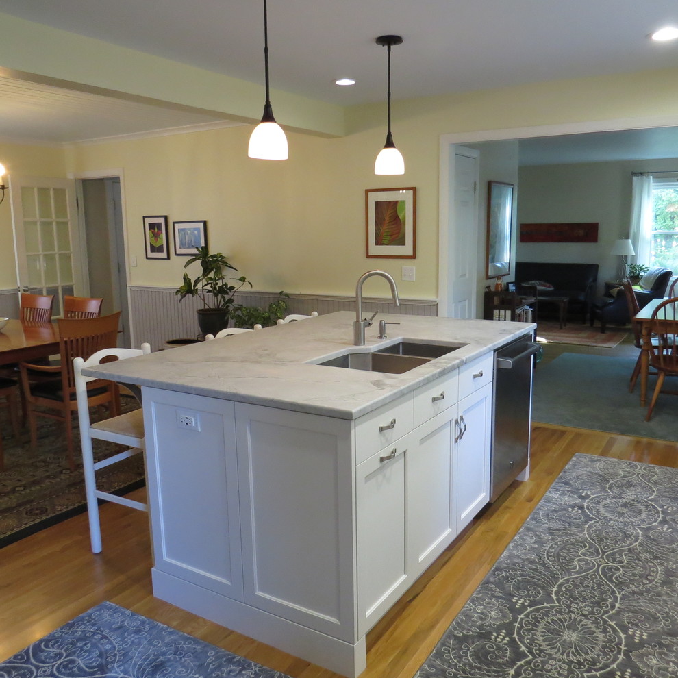 Transitional galley eat-in kitchen in Portland Maine with a double-bowl sink, recessed-panel cabinets, white cabinets, quartzite benchtops, yellow splashback, glass sheet splashback, stainless steel appliances, medium hardwood floors and with island.