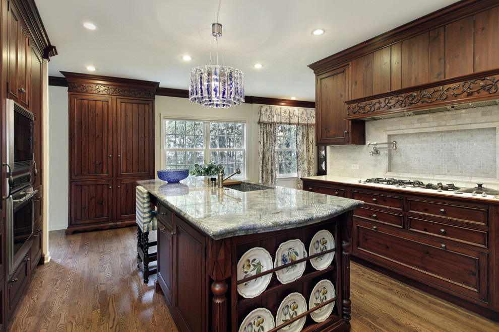 Photo of a traditional u-shaped eat-in kitchen in Philadelphia with an undermount sink, flat-panel cabinets, brown cabinets, granite benchtops, beige splashback, stone tile splashback and stainless steel appliances.