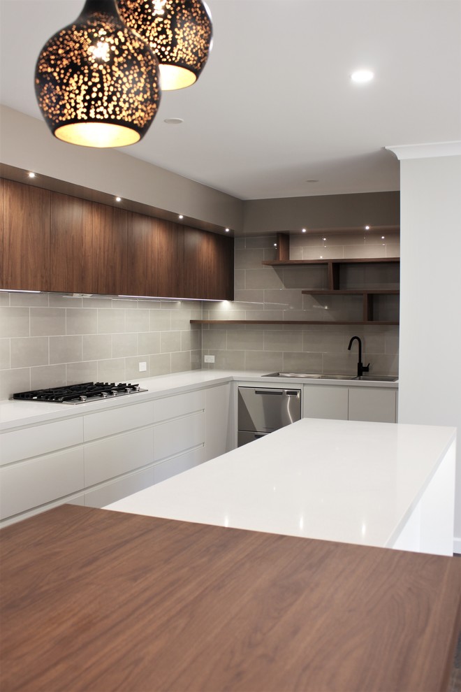 Inspiration for a large contemporary u-shaped open plan kitchen with an undermount sink, flat-panel cabinets, dark wood cabinets, quartz benchtops, beige splashback, ceramic splashback, stainless steel appliances, linoleum floors, with island, brown floor and white benchtop.