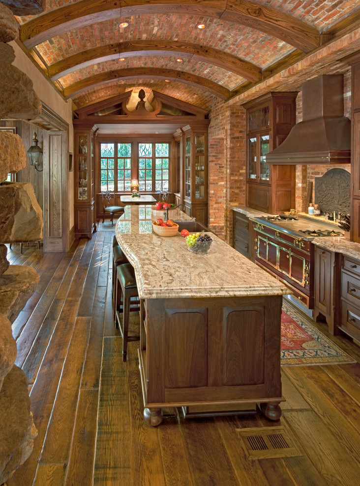 Inspiration for a large rustic single-wall dark wood floor eat-in kitchen remodel with a farmhouse sink, recessed-panel cabinets, dark wood cabinets, granite countertops, colored appliances and an island