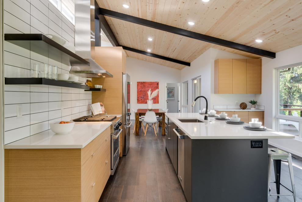Design ideas for an expansive midcentury single-wall eat-in kitchen in Portland with an undermount sink, flat-panel cabinets, light wood cabinets, quartz benchtops, white splashback, stainless steel appliances, dark hardwood floors, with island, white benchtop and wood.