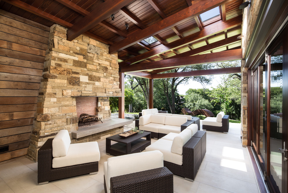 Country patio in Austin with a roof extension and with fireplace.