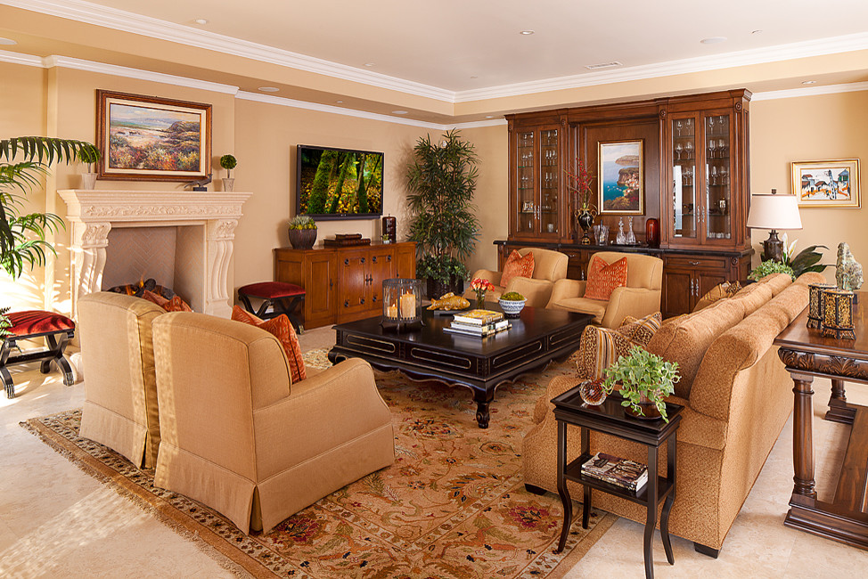 Photo of a large mediterranean enclosed family room in Orange County with a home bar, beige walls, ceramic floors, a standard fireplace, a plaster fireplace surround and a wall-mounted tv.