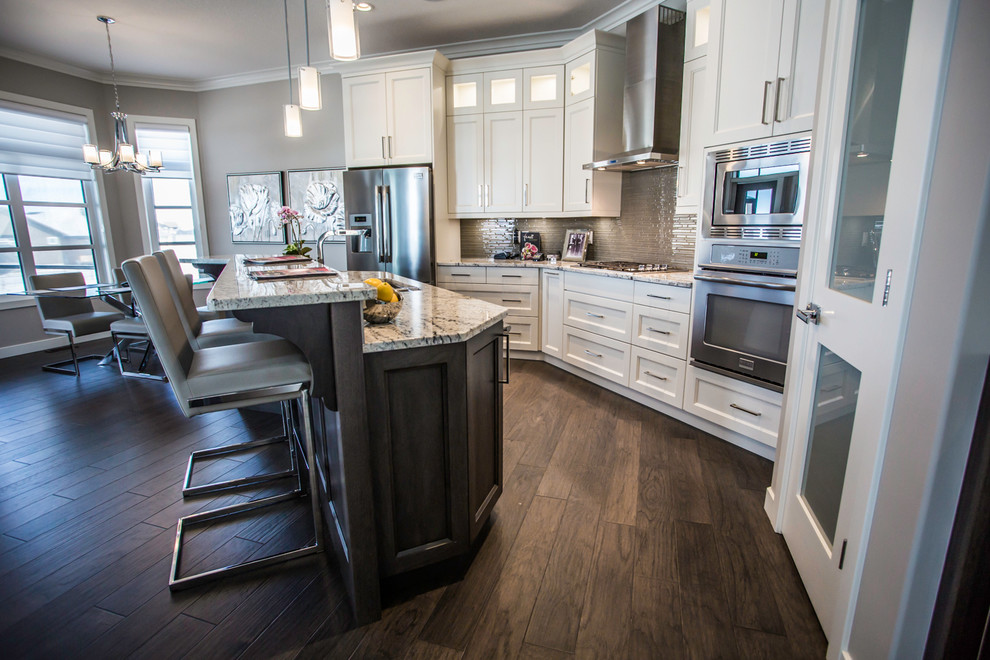This is an example of a large transitional single-wall open plan kitchen in Other with an undermount sink, shaker cabinets, white cabinets, brown splashback, stainless steel appliances, medium hardwood floors, with island and quartzite benchtops.