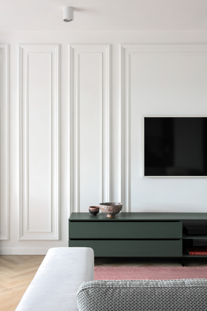 Modern inredning av ett mellanstort vardagsrum, med vita väggar, mellanmörkt trägolv, en väggmonterad TV och brunt golv