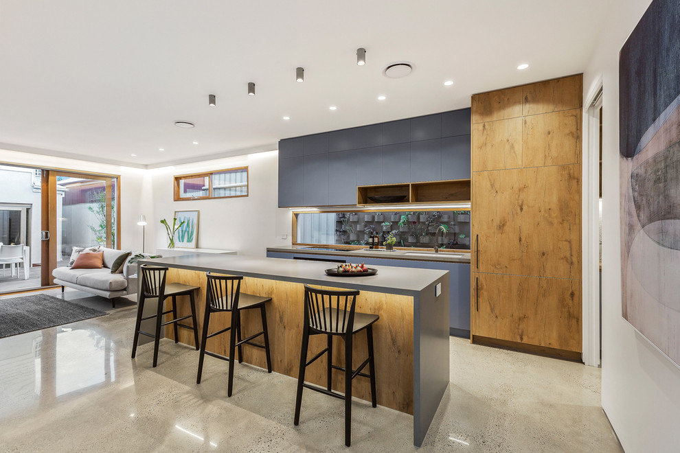 This is an example of a mid-sized contemporary open plan kitchen in Melbourne with an undermount sink, medium wood cabinets, concrete benchtops, window splashback, concrete floors, with island, grey floor and grey benchtop.