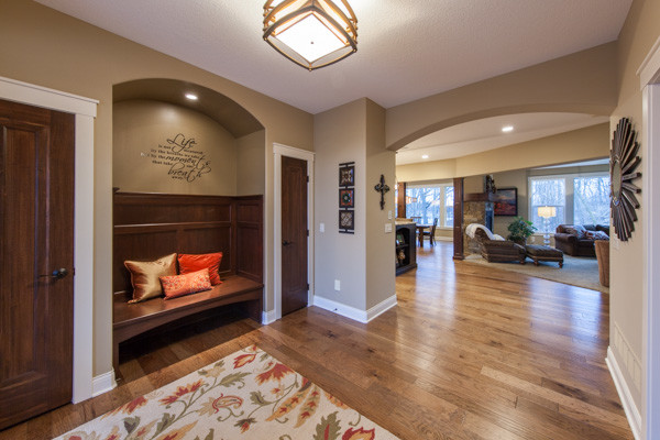 This is an example of a large transitional foyer in Minneapolis with brown walls, dark hardwood floors and brown floor.